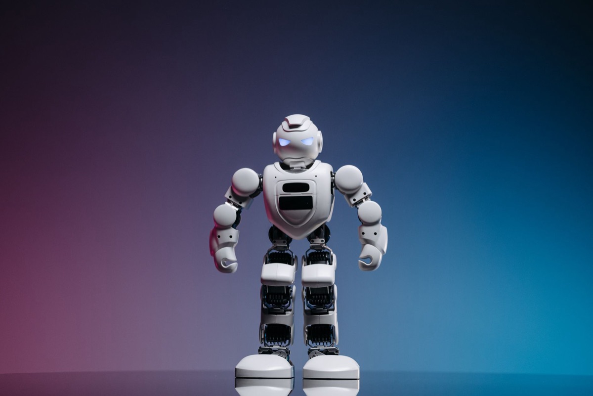 Trabajador en fábrica observa un robot: humano vs. automatización