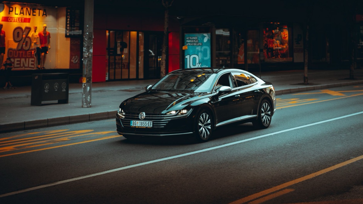 Carro elétrico moderno circulando por uma rua urbana.