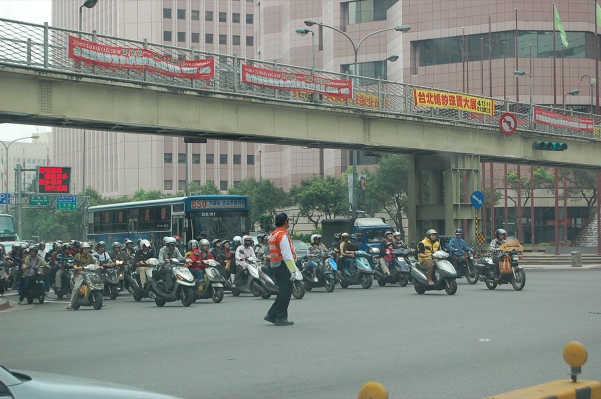 台灣台北市信義區人潮紛紜的觀光夜市，攤位燈光與街邊綠植交相輝映