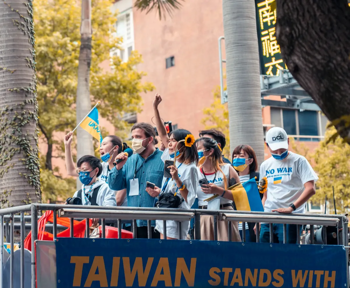 A group of diverse people at a peace rally in Taiwan with no war signs and flags.