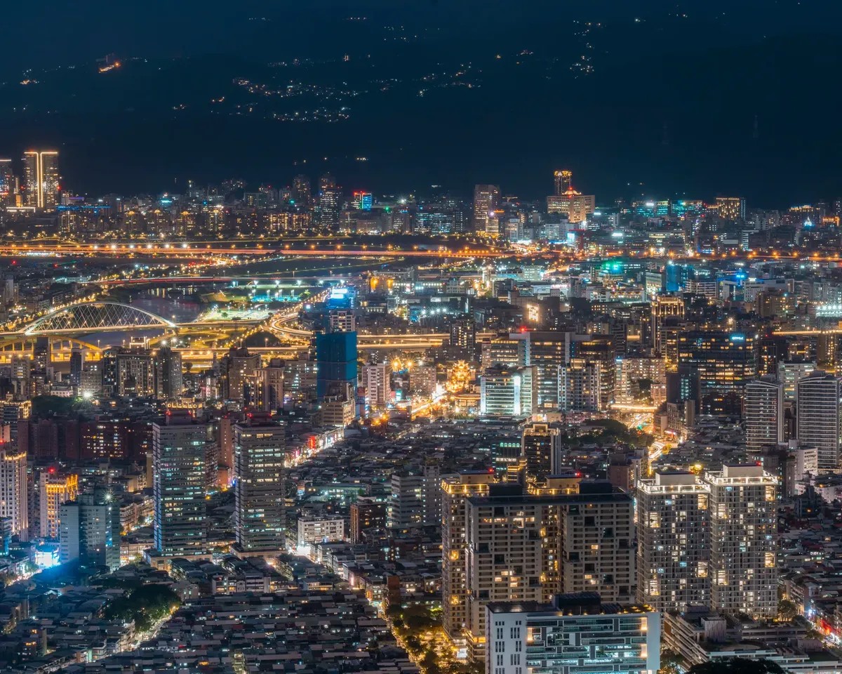 A breathtaking night view of Taipei city showcasing its modern illuminated skyline and architecture.